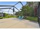Oversized screened lanai featuring comfortable seating and a scenic view of a tranquil pond at 30918 Burleigh Dr, Wesley Chapel, FL 33543