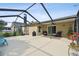 Large screened lanai with outdoor furniture and a view of the well-maintained backyard and lush landscaping at 30918 Burleigh Dr, Wesley Chapel, FL 33543