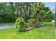 Landscaped flower bed with flowering shrubs, tropical plants and small trees at 30918 Burleigh Dr, Wesley Chapel, FL 33543