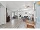 Bright living room with grey wood floors and modern furniture with an open concept design at 30918 Burleigh Dr, Wesley Chapel, FL 33543