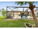 View of a large screened patio with outdoor seating and a grilling area, perfect for outdoor entertaining at 30918 Burleigh Dr, Wesley Chapel, FL 33543