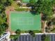 Pickleball court surrounded by trees, shrubs, and a sidewalk from a parking lot with benches nearby at 30918 Burleigh Dr, Wesley Chapel, FL 33543