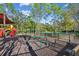 Exterior view of community playground with green bars, red slide and views of the tennis court at 30918 Burleigh Dr, Wesley Chapel, FL 33543