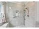 Clean and modern shower featuring updated tile, showerhead, built-in shelves, seating and glass door at 30918 Burleigh Dr, Wesley Chapel, FL 33543