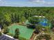 Aerial shot shows tennis courts in a wooded area close to parking and other community features at 30918 Burleigh Dr, Wesley Chapel, FL 33543