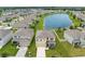 Aerial view of a well-planned community with a lake, showcasing homes with lush green yards at 30936 Summer Sun Loop, Wesley Chapel, FL 33545