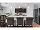 Charming kitchen boasts an island with seating, sleek countertops, stainless steel refrigerator, and abundant natural light at 30936 Summer Sun Loop, Wesley Chapel, FL 33545