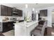 Modern kitchen features dark cabinets, stainless steel appliances, and a large island with seating at 30936 Summer Sun Loop, Wesley Chapel, FL 33545