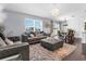 Open-concept living area featuring stylish sofas, an area rug, and seamless transition to the dining space with lake views at 30936 Summer Sun Loop, Wesley Chapel, FL 33545