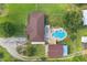 A bird's eye view of a yard featuring a pool, patio, lush lawn, and a quaint, well-maintained house at 3217 Mott Rd, Dover, FL 33527