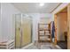 Compact bathroom featuring a walk-in shower stall, storage shelves, and simple fixtures for convenience at 3217 Mott Rd, Dover, FL 33527