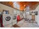 Practical laundry area featuring a wooden ceiling, appliances, and a sitting area with an ottoman at 3217 Mott Rd, Dover, FL 33527