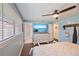 Light-filled main bedroom features wood floors, a ceiling fan, and access to an ensuite bathroom at 3217 Mott Rd, Dover, FL 33527