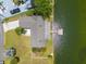 Aerial view of a home with a private dock on the water, showcasing lush greenery and a well-manicured lawn at 3226 Gardenia Dr, Hernando Beach, FL 34607