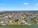 Wide aerial view showcasing canal-front homes in a waterfront community with access to the open water at 3226 Gardenia Dr, Hernando Beach, FL 34607