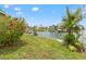 Waterfront view from a lush green lawn with a boat dock, and beautiful landscaping at 3226 Gardenia Dr, Hernando Beach, FL 34607