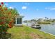 Beautifully landscaped backyard with a waterfront view, a boat dock, and a luxury home at 3226 Gardenia Dr, Hernando Beach, FL 34607
