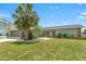 Charming single-story home featuring a well-maintained lawn, stone accents, and mature palm tree at 3226 Gardenia Dr, Hernando Beach, FL 34607
