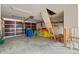 Large garage space with concrete floors, ladder to ceiling access, and storage along the back wall at 3226 Gardenia Dr, Hernando Beach, FL 34607