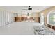 Spacious living room featuring light tile floors and a ceiling fan, undergoing renovation at 3226 Gardenia Dr, Hernando Beach, FL 34607