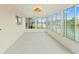 Bright sunroom featuring white tile flooring and large windows showcasing a scenic waterfront view at 3226 Gardenia Dr, Hernando Beach, FL 34607