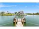 Expansive waterfront home with a private dock, boat, and lush landscaping under a blue sky at 3226 Gardenia Dr, Hernando Beach, FL 34607