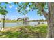 Lush green lawn and waterfront view of a luxury home with a boat dock and lush landscaping at 3226 Gardenia Dr, Hernando Beach, FL 34607