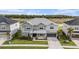 Aerial view of the two-story gray home with a two car garage next to a pond and walking bridge at 33774 Castaway Loop, Wesley Chapel, FL 33543
