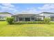 A large green lawn and screened in pool provide lots of space for recreation and outdoor fun at 33774 Castaway Loop, Wesley Chapel, FL 33543