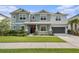 Charming two-story home with gray exterior, well-maintained lawn, and a covered front porch at 33774 Castaway Loop, Wesley Chapel, FL 33543