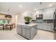 Modern kitchen with an island, stainless appliances, and adjacent dining area at 33774 Castaway Loop, Wesley Chapel, FL 33543