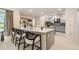 Modern kitchen island with seating, light gray cabinets, stainless steel appliances, and view of the backyard at 33774 Castaway Loop, Wesley Chapel, FL 33543