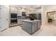 Modern kitchen with stainless steel appliances, gray cabinetry, a tile backsplash, and a central island with seating at 33774 Castaway Loop, Wesley Chapel, FL 33543