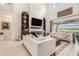 Bright living room featuring soaring ceilings, a modern fireplace, built-in shelves, and sliding glass doors to outdoor patio at 33774 Castaway Loop, Wesley Chapel, FL 33543