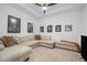 Cozy living room with a large sectional sofa, ceiling fan, and wall art for a relaxing atmosphere at 33774 Castaway Loop, Wesley Chapel, FL 33543