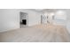 Bright, open living room with neutral carpeting, white walls, and ample space for versatile arrangement at 33774 Castaway Loop, Wesley Chapel, FL 33543