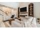 Spacious living room featuring a fireplace, built-in shelving, and comfortable seating, creating a cozy atmosphere at 33774 Castaway Loop, Wesley Chapel, FL 33543