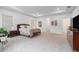Spacious main bedroom featuring neutral carpeting, tray ceiling, and ample natural light from multiple windows at 33774 Castaway Loop, Wesley Chapel, FL 33543