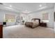 Expansive main bedroom with tray ceiling, neutral carpet, and large windows offering ample natural light at 33774 Castaway Loop, Wesley Chapel, FL 33543
