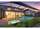 Inviting screened-in pool area with a spa and ample patio space, perfect for outdoor entertaining at 33774 Castaway Loop, Wesley Chapel, FL 33543