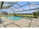 Beautiful backyard featuring a screened-in pool and spa, surrounded by lush landscaping at 33774 Castaway Loop, Wesley Chapel, FL 33543