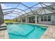Stunning pool area with a screened enclosure, outdoor kitchen, and plenty of space for dining and lounging at 33774 Castaway Loop, Wesley Chapel, FL 33543