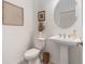 Bright powder room featuring a pedestal sink, framed art, and modern fixtures at 33774 Castaway Loop, Wesley Chapel, FL 33543