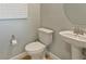 Bright half bathroom featuring a pedestal sink, updated fixtures, and a modern toilet at 3424 Timber Crossing Ave, Brandon, FL 33511