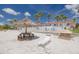 Beach view with tiki hut, lounge chairs, and picnic table at 3595 41St S Ln # L, St Petersburg, FL 33711