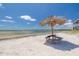 White sandy beach with a tiki hut and ocean view at 3595 41St S Ln # L, St Petersburg, FL 33711