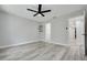 Spacious bedroom with wood-look floors, a ceiling fan, and access to an ensuite bathroom and walk-in closet at 3595 41St S Ln # L, St Petersburg, FL 33711