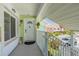 Charming front entrance featuring a covered porch, white door with decorative window, and vibrant green accents at 3595 41St S Ln # L, St Petersburg, FL 33711