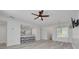 Bright, open-concept living room with wood-look floors, white walls, ceiling fan and kitchen bar seating at 3595 41St S Ln # L, St Petersburg, FL 33711
