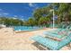 Bright community pool area with lounge chairs, clear water, and lush tropical surroundings at 3595 41St S Ln # L, St Petersburg, FL 33711